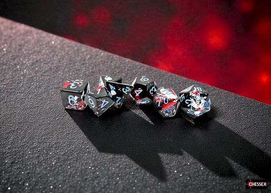 Set of black dice with a red and white brushed design and blue numbers on a dark surface