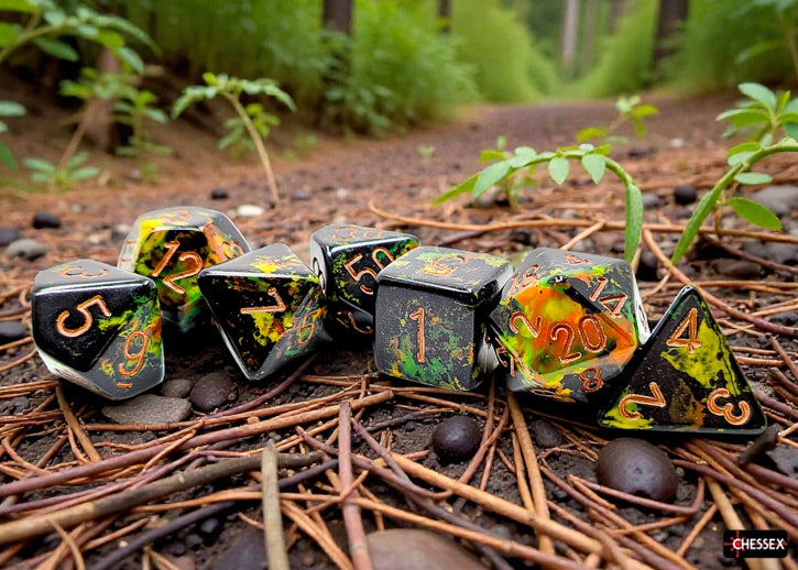 Set of Chessex dice with black, green, and orange design on a forest floor background