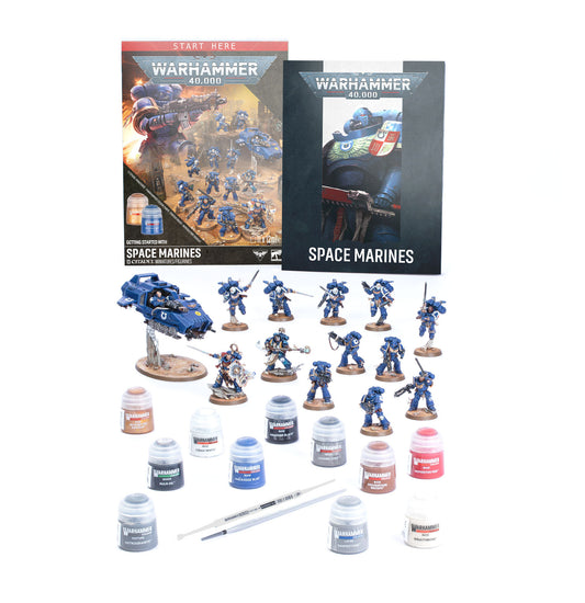 Warhammer 40k Space Marines miniatures kit on a white background, including painted blue space marine figures, a blue vehicle, multiple paint bottles, a brush, and two product boxes.