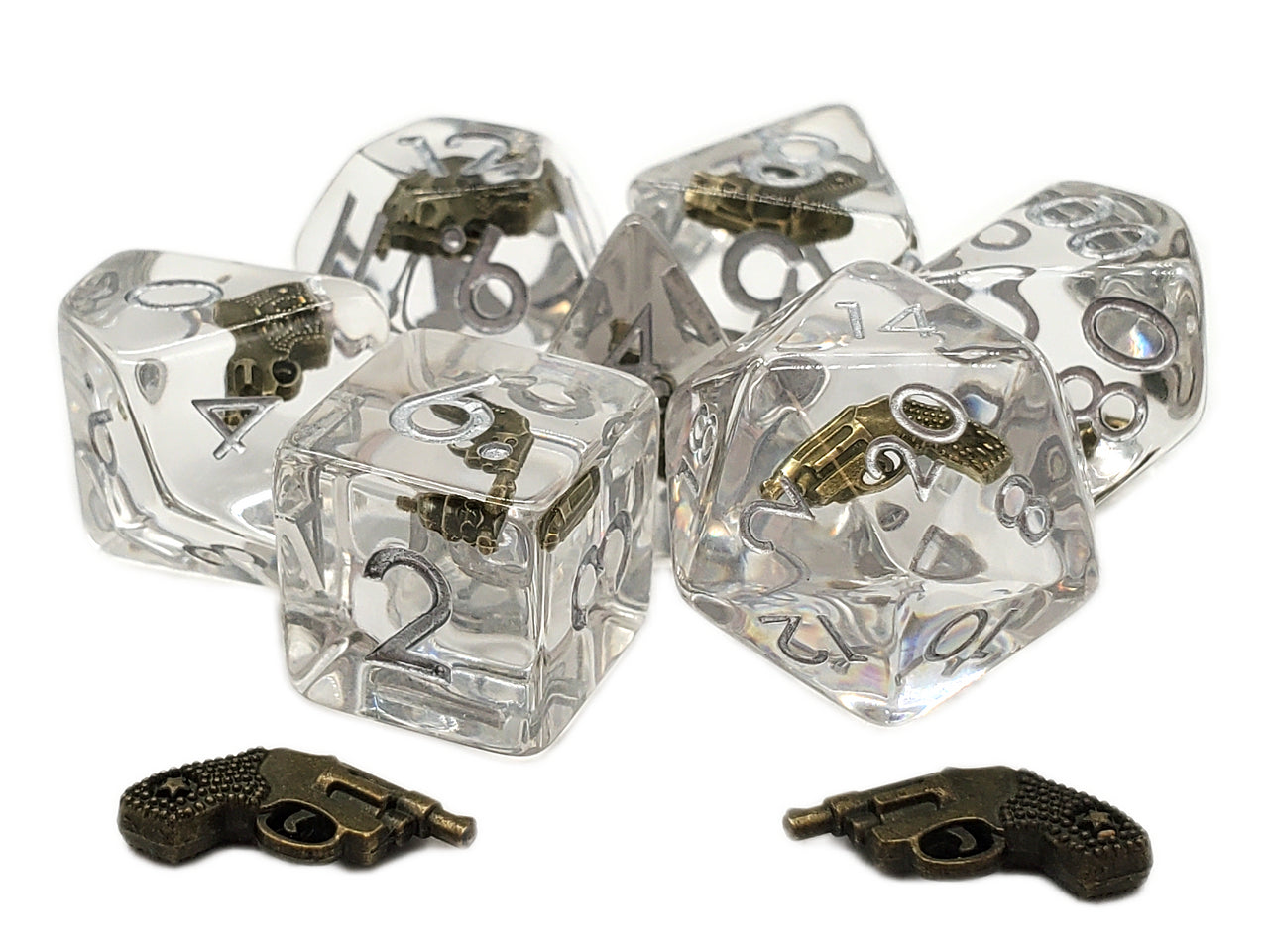 Clear dice with brass gun designs on a white background