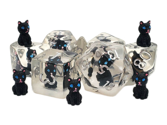 Clear dice with black cat figurines on a white background