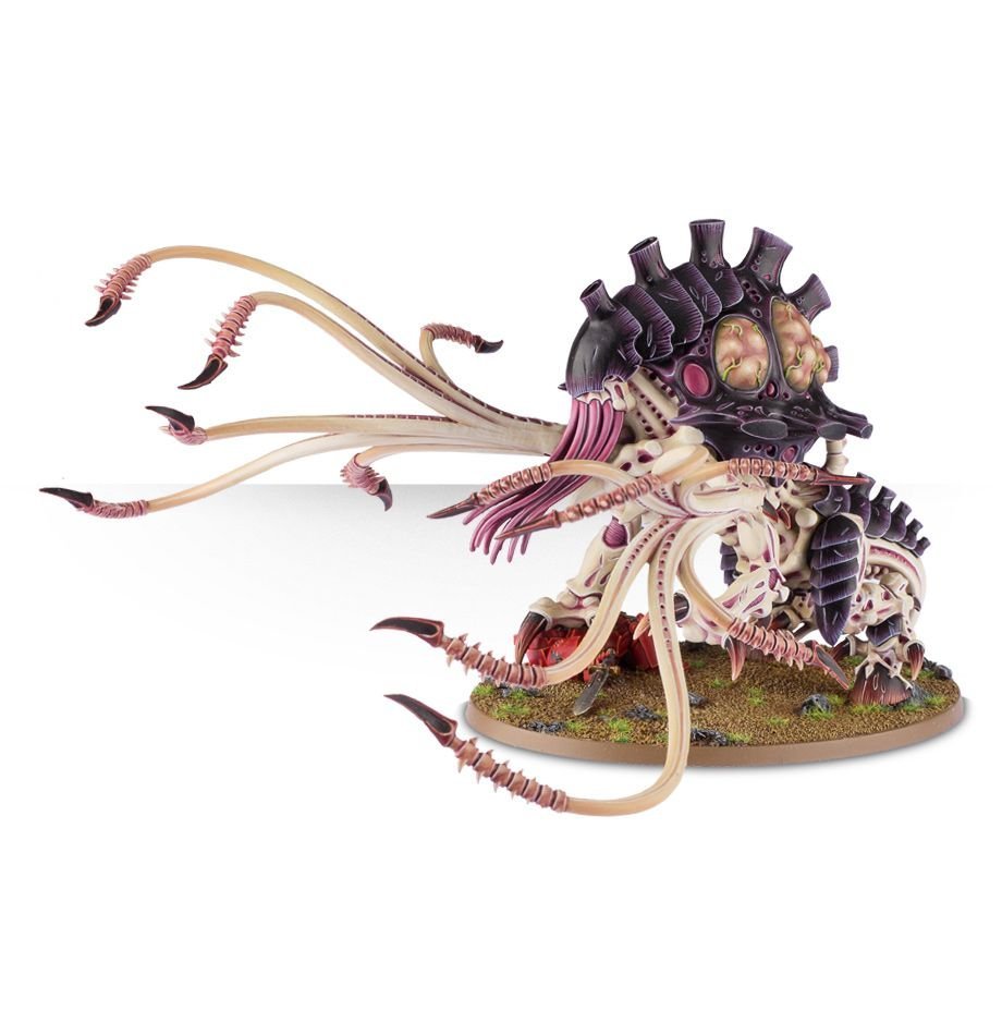 A detailed model of a Tyranids Toxicrene from the Warhammer 40,000 universe. The creature has a large, armored carapace with multiple spines and tendrils extending from its back. It is painted in shades of purple and beige, with greenish pustules on its back and sharp claws on its limbs. The base is decorated with grass and rocks to simulate a natural environment.
